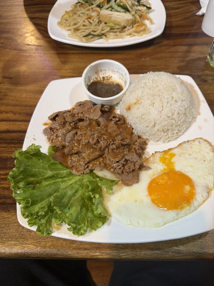 Beef lok lak with rice, a fried egg, and dipping sauce