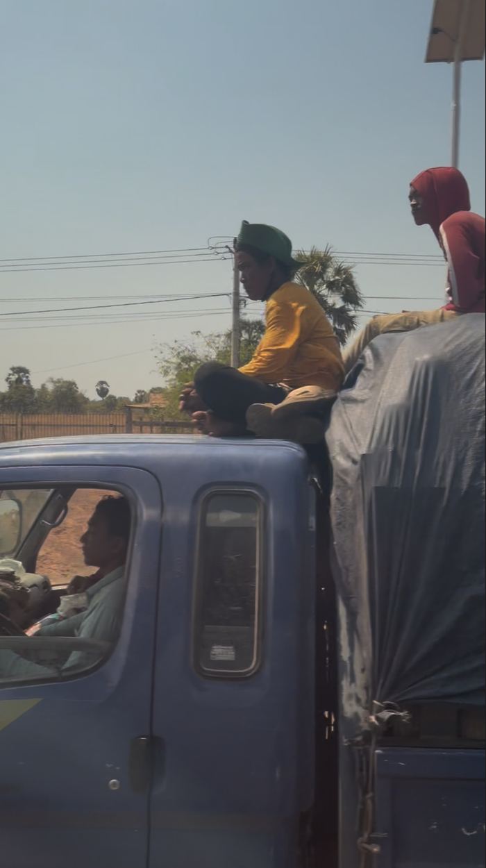People riding on top of a loaded truck