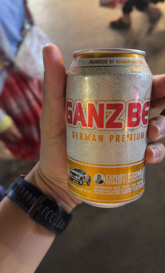 Holding a can of Ganz beer