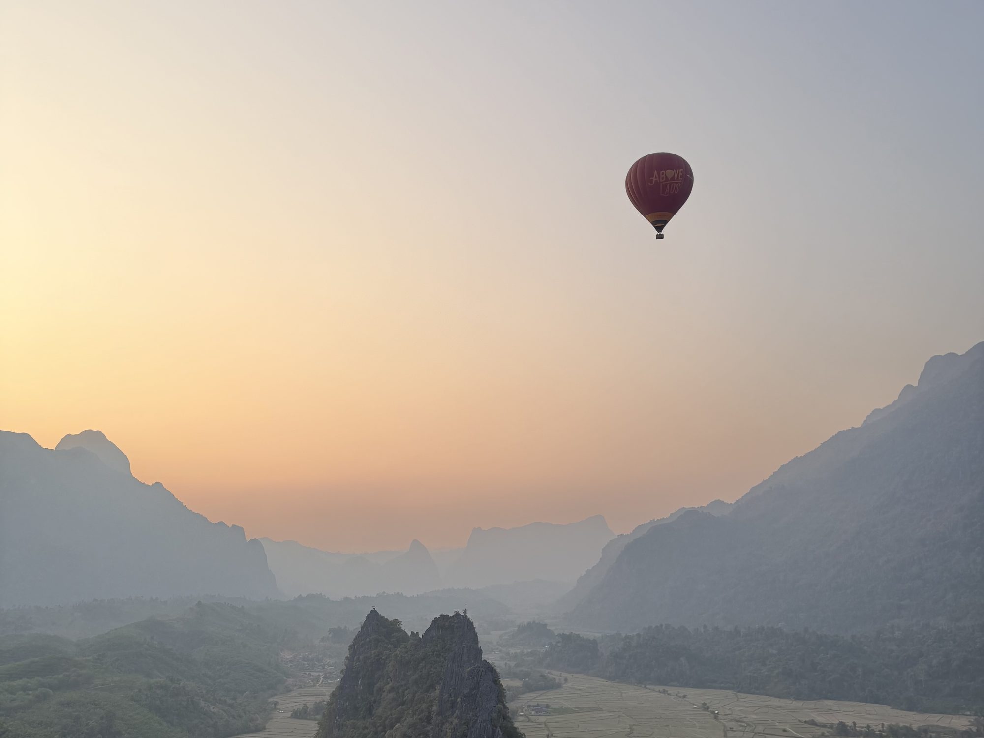 A hot-air balloon over the karst mountains of Vang Vieng, Laos, at sunrise