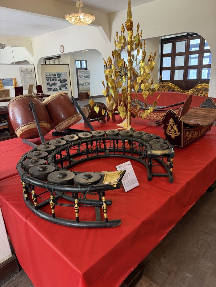 Traditional Lao instruments, including a circle of gongs, on display