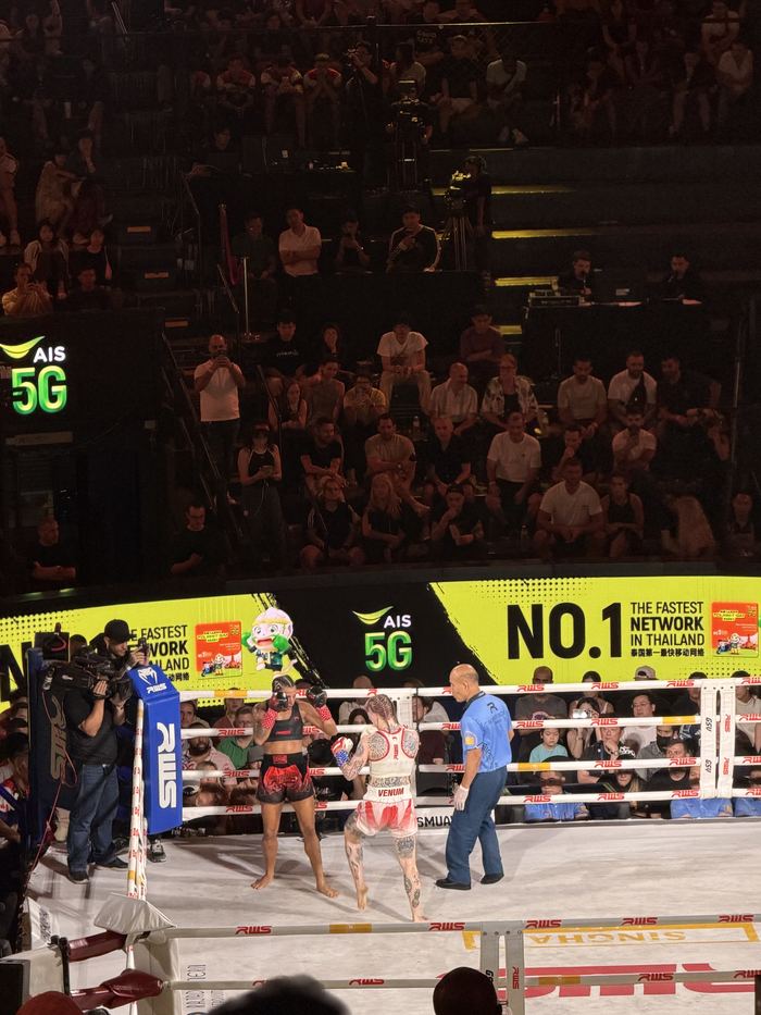 Fighters in the ring at a packed Muay Thai stadium