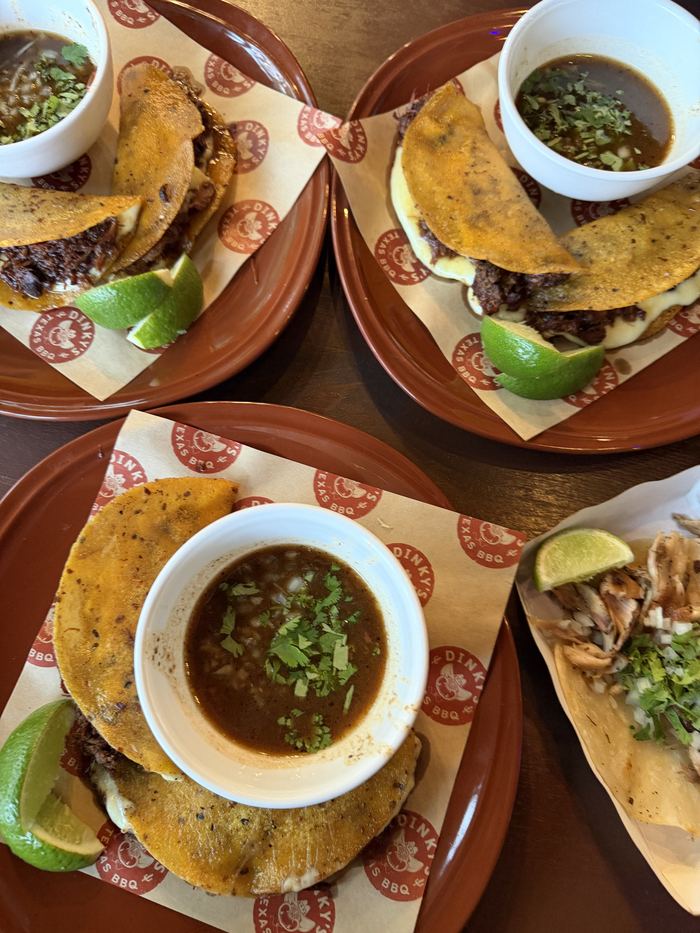 Birria tacos with bowls of consomme