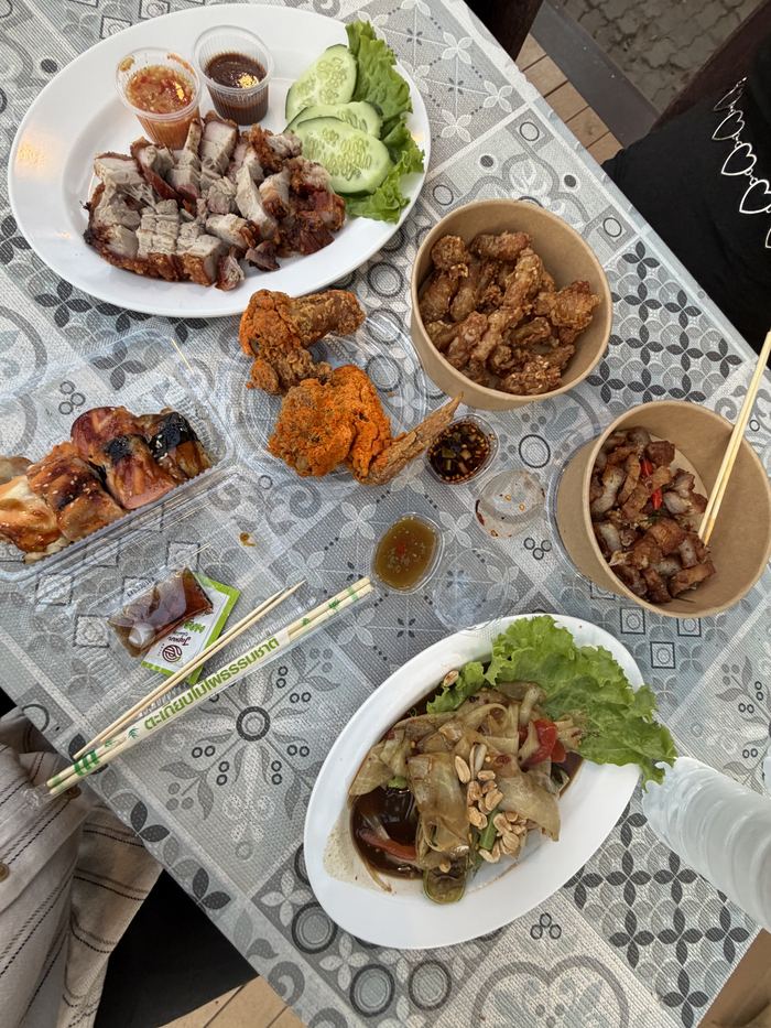A table of crispy pork, fried chicken, and papaya salad