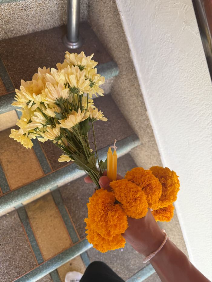 Holding marigold garlands and flowers as temple offerings