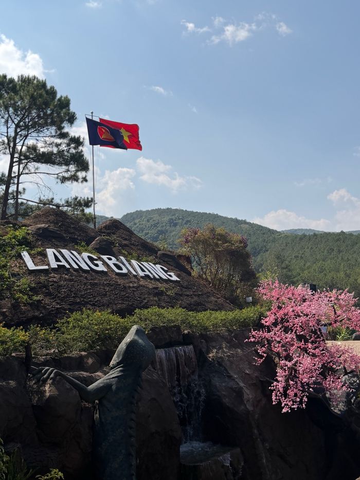 The Langbiang sign above flowers on a hilltop