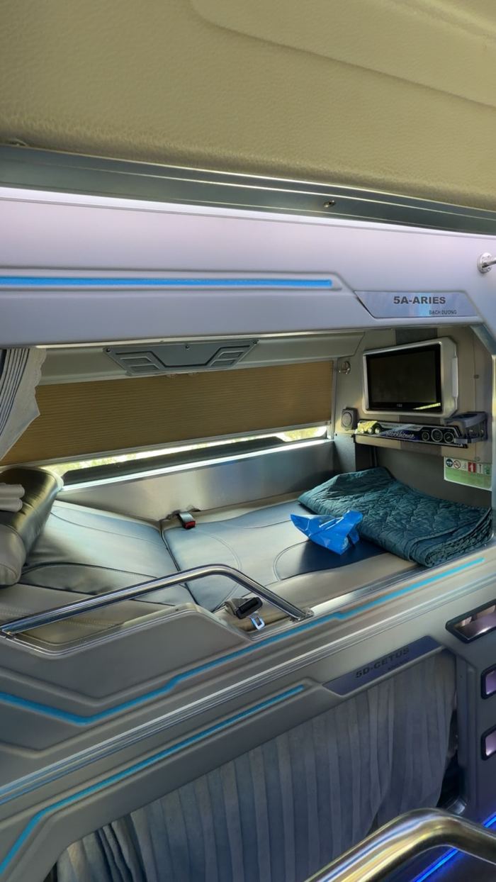 A sleeper bus pod with a screen and a blanket