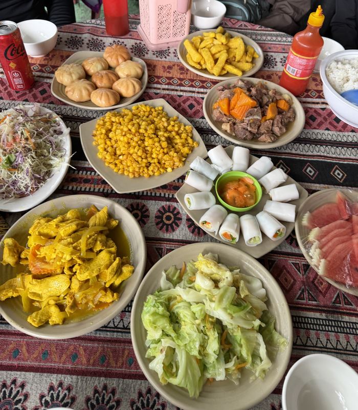A table covered with shared dishes on a patterned cloth