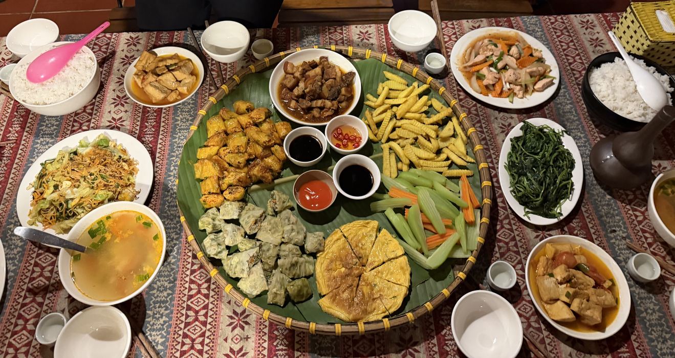 A big tray of shared dishes surrounded by side plates