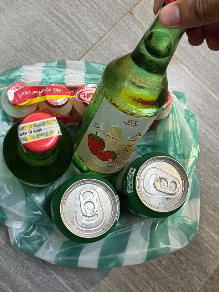 A bag of beers and a bottle of strawberry soju