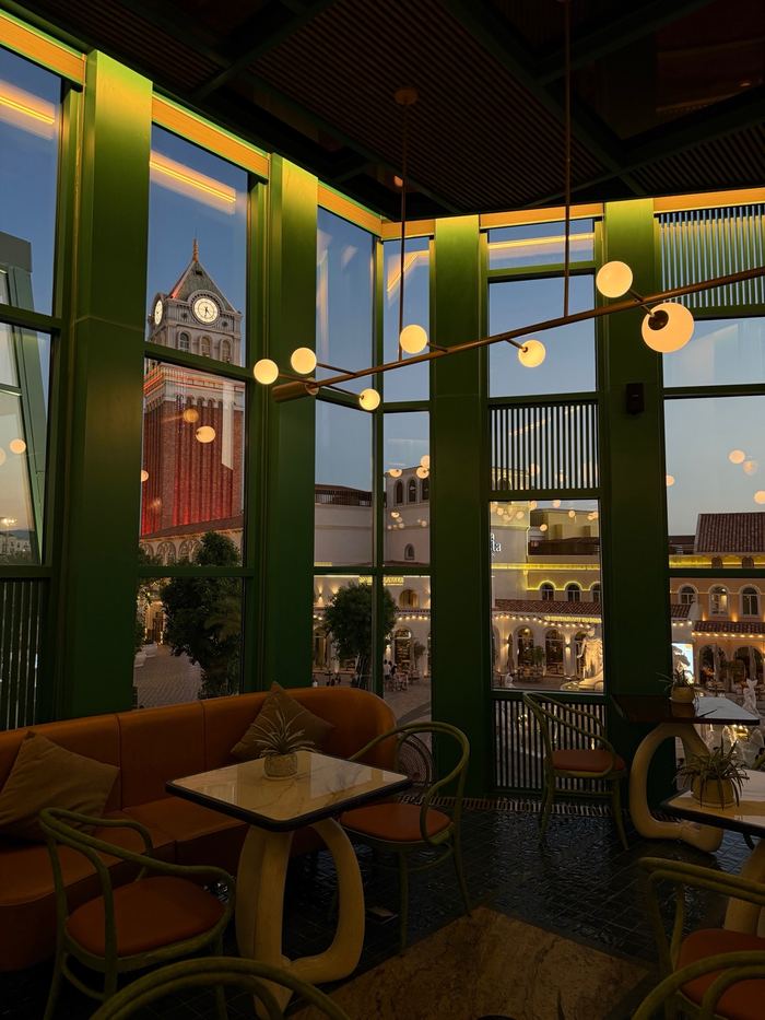 A cafe with tall windows looking out on colorful buildings