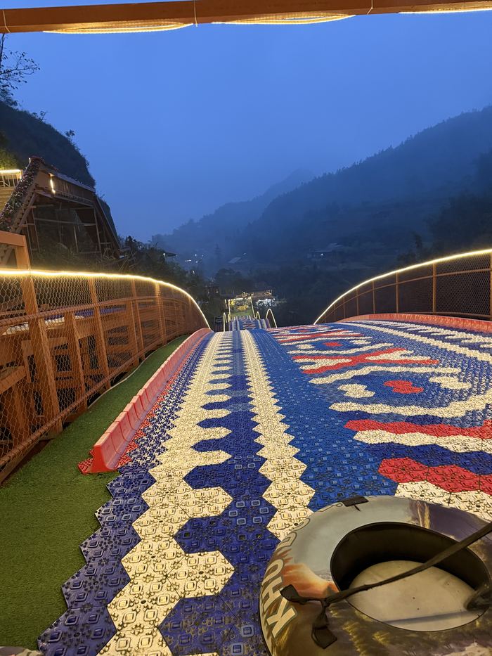 A long mosaic-patterned slide running down the mountainside