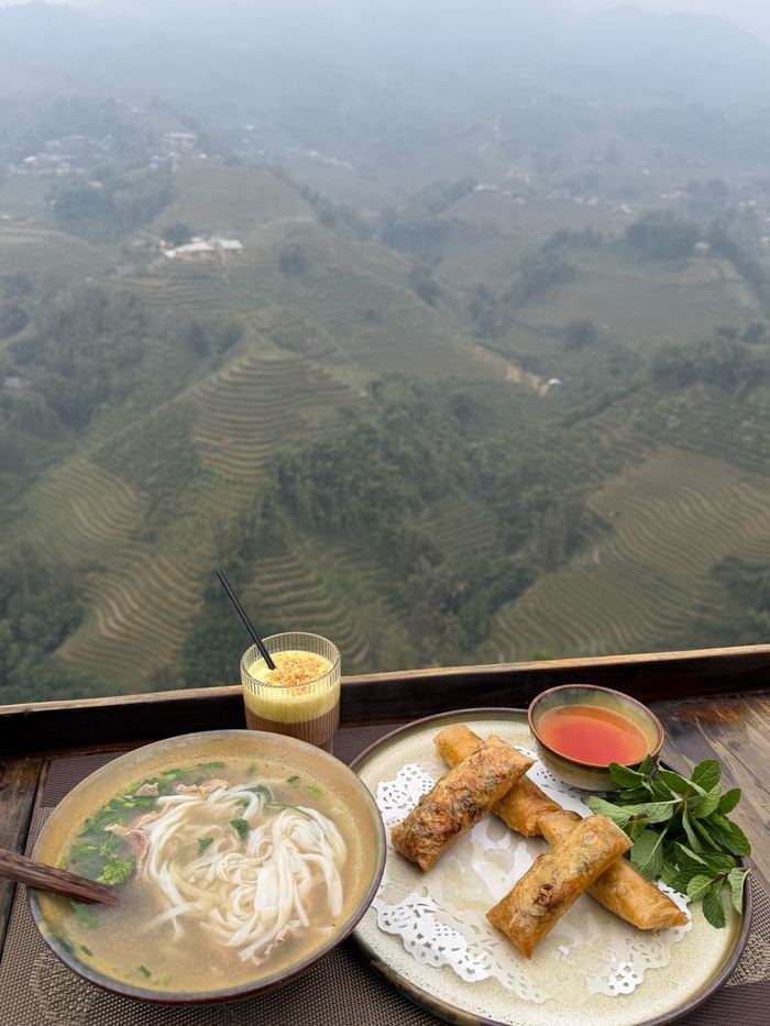 Noodle soup and spring rolls with rice terraces in the background