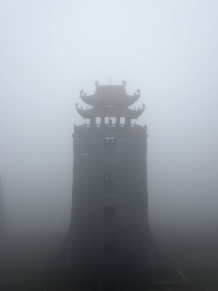 A tower fading into thick fog